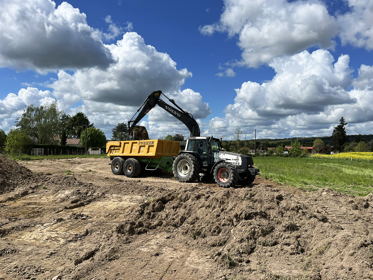Tracteur et benne évacuant la terre du chantier